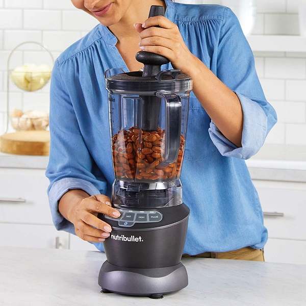 a woman using NutriBullet Blender Combo to crush almonds