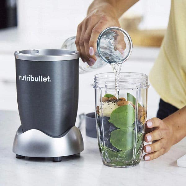 Nutribullet 600 is being used by a woman to blend smoothie