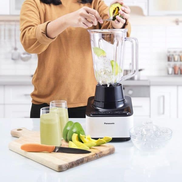 woman using a blender to make smoothie